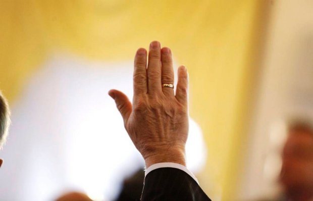 Zdjęcie przedstawia uniesioną rękę w trakcie głosowania